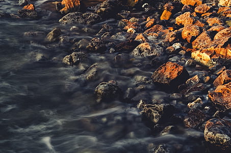 photo of water stream near rocks during daytime thumbnail