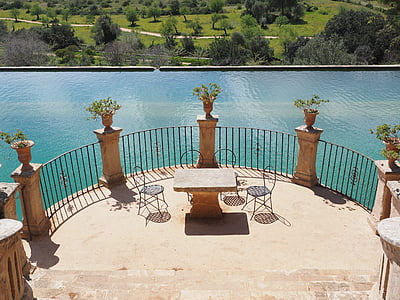 brown concrete patio set beside body of water during daytime thumbnail