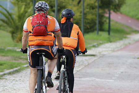 man and woman riding bicycle on concrete road during daytime thumbnail
