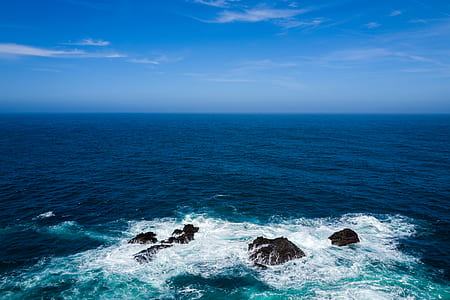 landscape photography of body of water under blue sky thumbnail