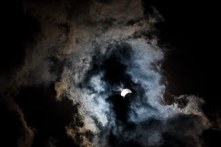 worm's-eye view photography of crescent moon surrounded by clouds thumbnail