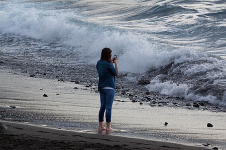 woman taking picture of the seawave thumbnail