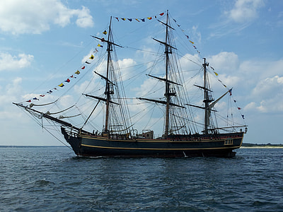 white and blue galleon ship on body of water under white clouds during daytime thumbnail