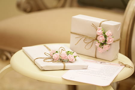 two white-and-pink floral gift boxes on white wooden table thumbnail