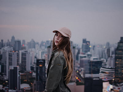 woman wearing gray cap with high-rise building background thumbnail