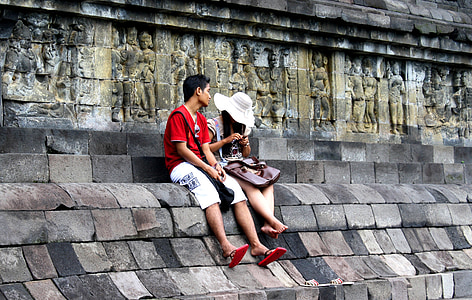 man and woman sitting on gray pavement thumbnail