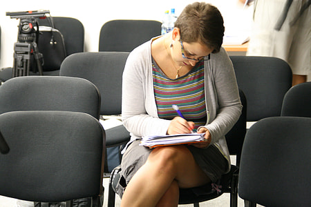 woman in gray long-sleeve shirt while writing thumbnail