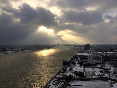 Sun shining through the clouds on the river in Detroit, Michigan thumbnail