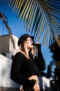 photo of a woman wearing black crop top standing near green leaf thumbnail