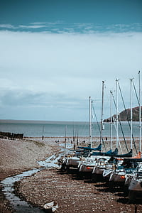 board parked on seashore under white clouds and blue sky at daytime thumbnail