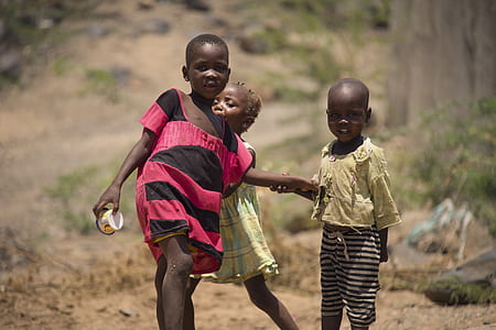 three children walking on road during daytime thumbnail