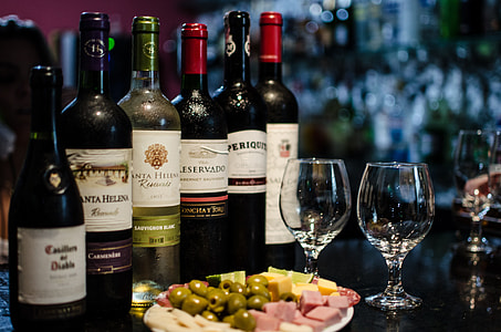 assorted-brand liquor bottles beside wine glasses thumbnail
