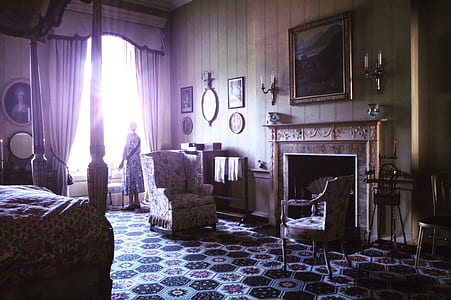 woman standing beside window in room thumbnail