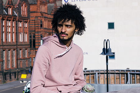 man wearing pink pullover hoodie near black lamp post thumbnail