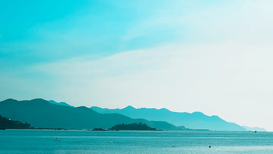 Silhouette of Mountain Near the Body of Water Photo in Daytime thumbnail