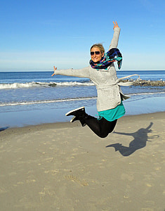 woman jumping on near body of water thumbnail