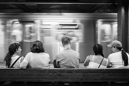 five people sitting on bench while waiting for the train arrive thumbnail