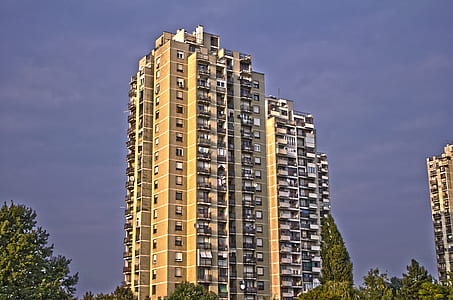 beige and black concrete high-rise building near trees thumbnail