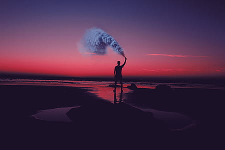 silhouette of man standing on shallow water thumbnail