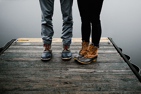 two person standing on brown wooden surface while wearing duck boots thumbnail