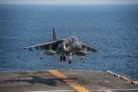 gray fighter plane landing on warship thumbnail