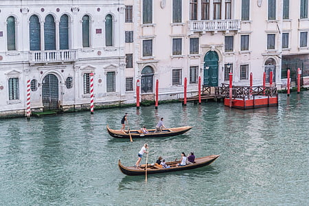 two group of people rowing on two brown boats thumbnail