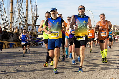 group of men running on road during daytime thumbnail