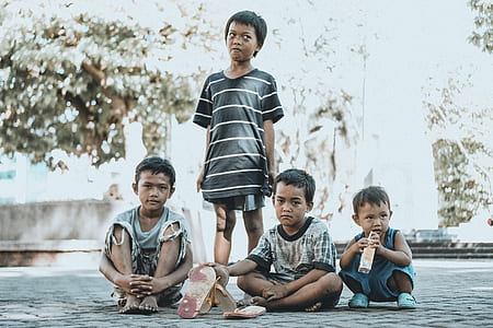 three boys sitting near the standing boy thumbnail