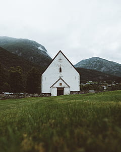 white house near mountains under white clouds thumbnail