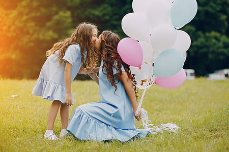 two girls kissing together during daytime thumbnail