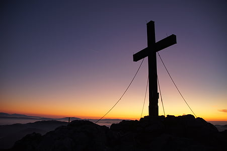silhouette of cross on mountain peak during golden hour thumbnail