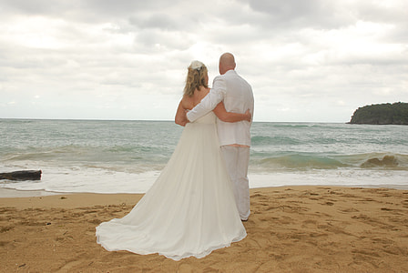 bride and groom on seashore near sea wave thumbnail