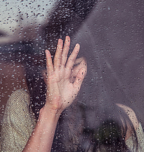 woman leaning on glass during rain thumbnail