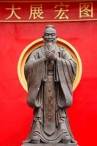 brown concrete human statue near red textile thumbnail