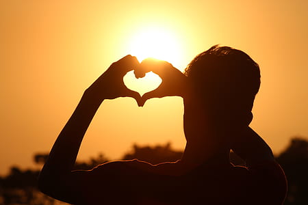 Silhouette Photo of Man Doing Heart Sign during Golden Hour thumbnail