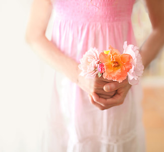 woman in pink and white dress holding flowers thumbnail