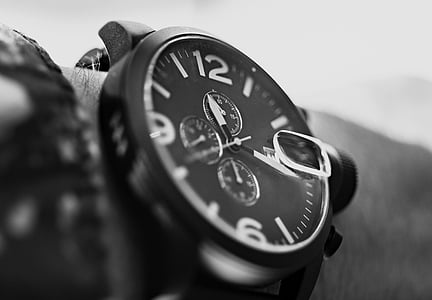 close up photograph of person wearing round bezel chronograph watch thumbnail