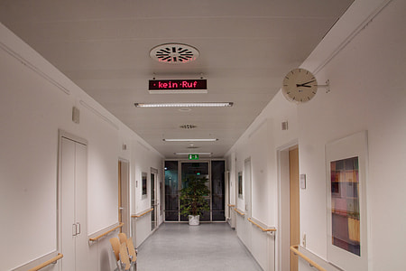 black and red signage on the ceiling in the middle of the hallway thumbnail