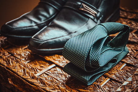 photo of folded green necktie beside pair of black leather dress shoes thumbnail