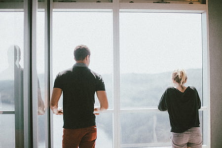 man and woman leaning against window pane thumbnail