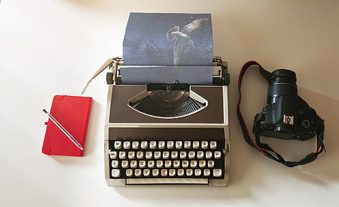 typewriter beside DSLR camera thumbnail