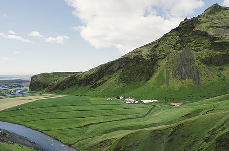 white and brown houses near mountain and river at daytime thumbnail