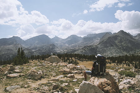 man with hiking backpack resting on rock thumbnail