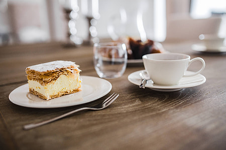 Sweet dessert with cream and a cup of coffee on a table thumbnail