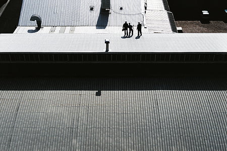 silhouette of three men walking in the street thumbnail