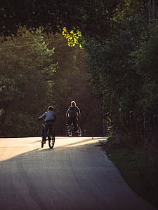 two boys riding bicycle on empty road during daytime thumbnail