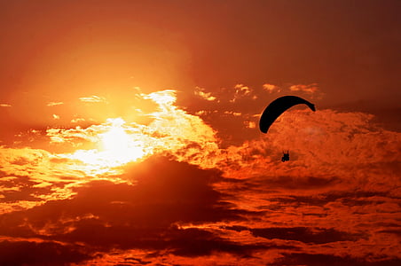 person riding parachute near clouds thumbnail