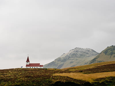 white and red concrete house in front of mountain thumbnail