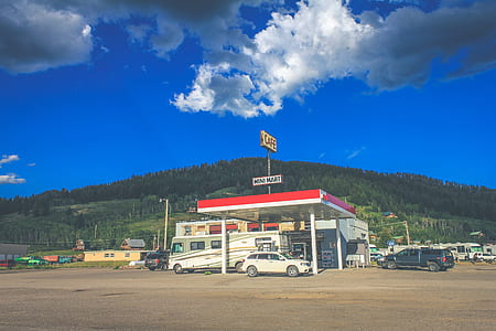 white and blue cars on gas station thumbnail