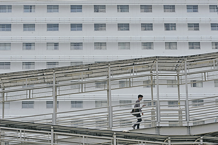 man walks on gray steel bridge thumbnail